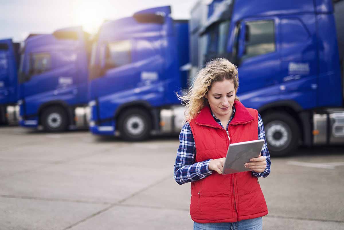 Truck driver holding tablet and checking route for new destinati